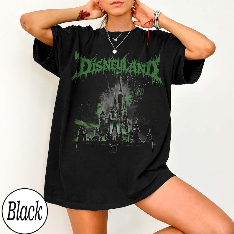 May include: Black t-shirt with a green graphic that says "Disneyland" in a gothic font. The graphic features a castle with fireworks in the background. The shirt is a relaxed fit.