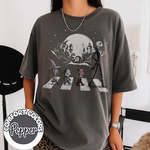 Peut inclure: T-shirt gris fonc&eacute; Comfort Colors avec un motif de personnages traversant un passage pi&eacute;ton devant une pleine lune et une ville effrayante. Le t-shirt porte les logos Comfort Colors et Pepper.