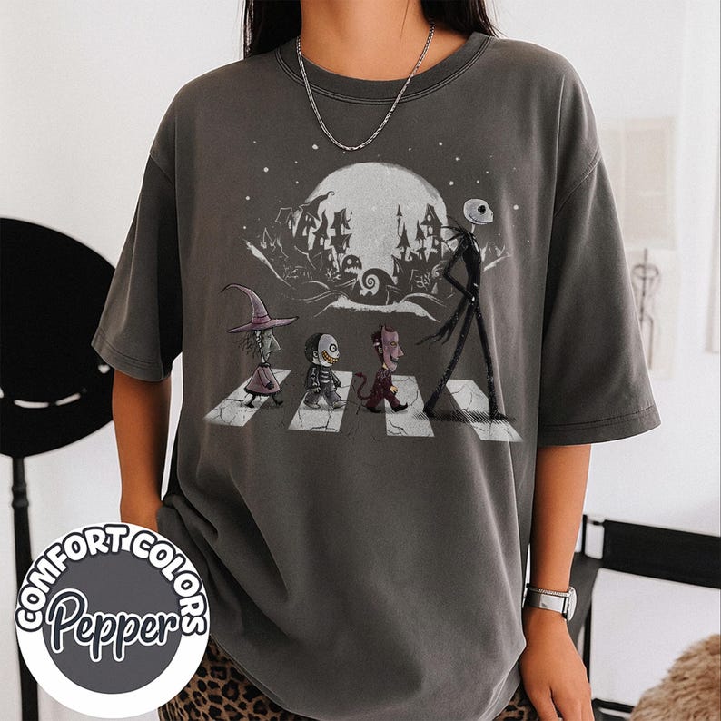 Peut inclure: T-shirt gris fonc&eacute; Comfort Colors avec un motif de personnages traversant un passage pi&eacute;ton devant une pleine lune et une ville effrayante. Le t-shirt porte les logos Comfort Colors et Pepper.
