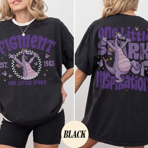 May include: Black oversized t-shirt with a white collar featuring a purple graphic of a dragon and the text "Figment est. 1983 one little spark" on the front. The back of the shirt has a matching graphic and the text "one little spark of inspiration".