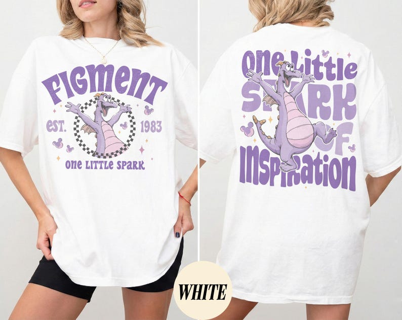 May include: White t-shirt featuring a purple dragon graphic with the text "Figment" and "One Little Spark" on the front. The back of the shirt has a matching design with the words "One Little Spark of Inspiration".