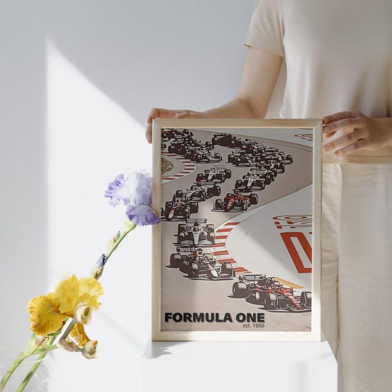 May include: A framed poster with a vintage illustration of Formula One race cars on a track. The poster has a beige background with red and white accents. The text "FORMULA ONE est. 1950" is printed at the bottom of the poster.