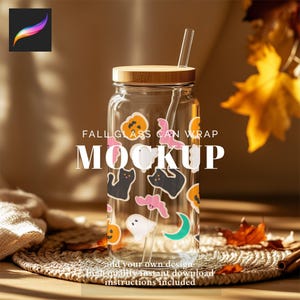 May include: A clear glass can-shaped mockup with a bamboo lid and a glass straw. The glass is decorated with Halloween-themed stickers, including pumpkins, bats, cats, and ghosts. The text "FALL GLASS CAN WRAP MOCKUP" is printed on the glass.