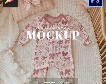 May include: A baby pajama mockup with a pink bow pattern. The pajamas have a zipper closure and are displayed on a white surface with a pillow and blanket. Text on the image reads "BABY PAJAMAS MOCKUP" and "add your own design high quality instant download instructions included."