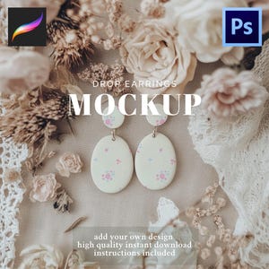 Op de afbeelding: Een mockup-afbeelding met oorhangers. De oorbellen zijn gebroken wit met een bloemmotief in roze en blauw. Het woord 'MOCKUP' staat prominent afgebeeld. De afbeelding bevat bloemstukken en software-pictogrammen.