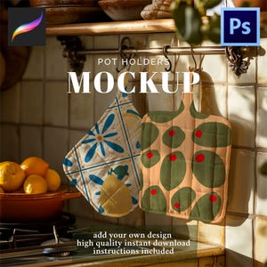 May include: Two pot holders with different designs hang from a metal bar. One has a blue and white floral pattern, and the other features green olive shapes with red accents on a tan background. The word "MOCKUP" is displayed.