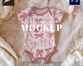 May include: A light pink infant bodysuit mockup featuring a pattern of various pink bows. The bodysuit has a dark pink trim and is displayed on a textured surface. Text on the bodysuit reads "INFANT BODYSUIT MOCKUP".