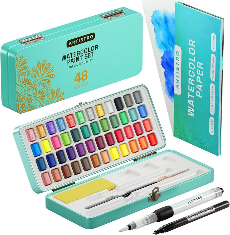 May include: A set of 48 watercolor paints in a teal metal tin with a floral design. The tin is open and shows the paint pans arranged in rows. The set also includes two brushes and a sheet of watercolor paper. The paper is 7.5 inches by 10.8 inches and is 300 gsm. It is acid-free.