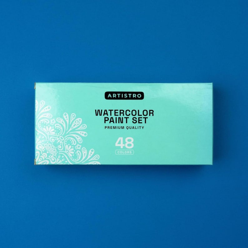 May include: A blue box with a white design on the front. The box contains a watercolor paint set with 48 colors. The text on the box reads "ARTISTRO WATERCOLOR PAINT SET PREMIUM QUALITY 48 COLORS".