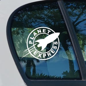 May include: A white Planet Express sticker, with a rocket ship emblem inside a circular design. The words "PLANET EXPRESS" are in a bold font. The sticker is displayed on a car window.