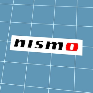 May include: A white rectangular sticker featuring the word "nismo" in black, with the letter "o" in red. The sticker is set against a blue grid background.