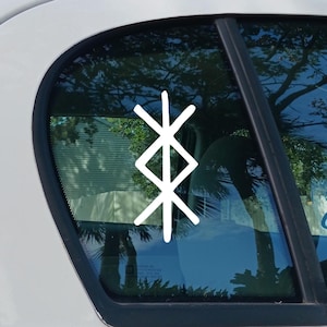 May include: White vinyl decal of a bind rune, a symbol combining multiple runes, affixed to a car window. The symbol is a combination of two runes, one vertical and one horizontal, creating a unique design.