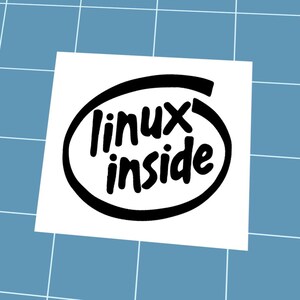 May include: A white sticker featuring the text "linux inside" in a black, stylized font, set within a black oval. The sticker is placed on a blue grid background.