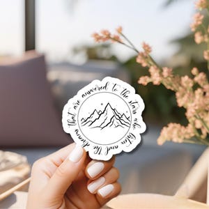 K&ouml;nnte beinhalten: Ein wei&szlig;er Aufkleber mit einer schwarzen Bergkette und Sternen in einem Kreis. Der Text um den Kreis herum lautet "Deine Tr&auml;ume werden zu den Sternen oben beantwortet."