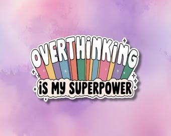 Può includere: Un adesivo con un arcobaleno e il testo "Overthinking is my superpower" in lettere nere.