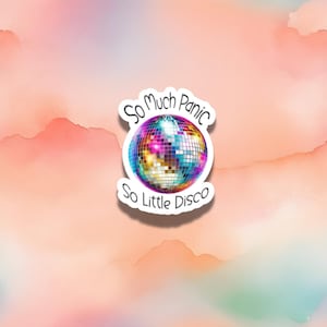Peut inclure: Un autocollant avec une boule disco et le texte "So Much Panic So Little Disco" sur un fond aquarelle rose et orange.