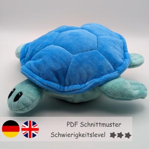以下が含まれることがあります： 青と緑のぬいぐるみ亀の縫製パターン。このパターンは初心者向けのプロジェクトです。このパターンは英語とドイツ語の両方で入手できます。