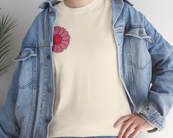 Può includere: Una maglietta bianca con una grafica di un fiore rosa e rosso sul lato sinistro. La maglietta è indossata da una persona che indossa una giacca di jeans blu.