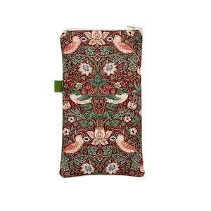 May include: A rectangular zipped pouch with a detailed floral and bird pattern in red, green, and white. The design features stylized birds and botanical elements. A small green tab is attached to the side. The pouch is likely made of fabric.