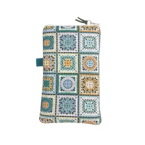 May include: A teal zippered pouch with a crocheted pattern in shades of green, yellow, and white. The pouch has a teal fabric tab.