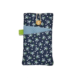 May include: A navy blue fabric phone case featuring a floral pattern of small blue flowers and white accents. The case has a light blue pocket with white polka dots and a green tab. A wooden button and string closure secures the top.
