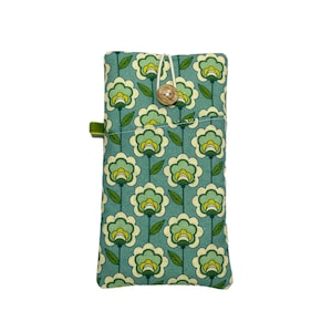 May include: A teal fabric case with a repeating floral pattern in white, light green, and yellow. It features a wooden button closure and a green tab. The case is designed for a phone or small items. The dimensions are approximately 10 cm x 18 cm.