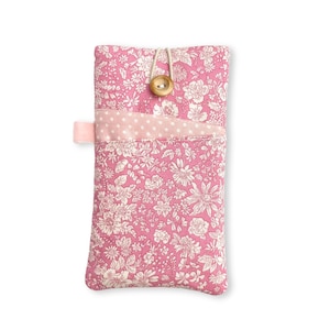 May include: A rectangular fabric pouch featuring a pink and white floral pattern. The pouch includes a front pocket with a light pink and white polka dot design, secured by a single wooden button and a loop closure on the top centre edge.