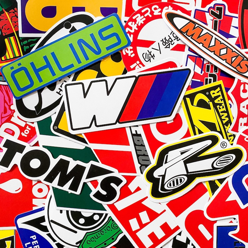 Pode incluir: Uma cole&ccedil;&atilde;o de autocolantes coloridos com v&aacute;rios log&oacute;tipos e texto. Os autocolantes apresentam marcas como Ohlins, Maxxis e Tom's. Os autocolantes t&ecirc;m v&aacute;rias formas e tamanhos, com uma mistura de texto e designs gr&aacute;ficos.