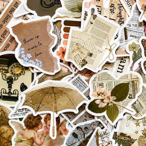 May include: A collection of vintage-style stickers with various designs. Includes a torn paper sticker with the text "there is more to love", a beige umbrella, and newspaper clippings. The color palette is primarily beige, brown, and white.