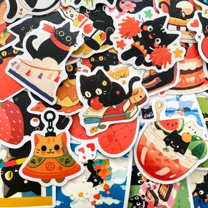 May include: A collection of colorful cat-themed stickers. The stickers feature various black cats in different poses, including holding apples, wearing pom-poms, and enjoying desserts. Other stickers include a cat keychain and a cat in a drink.