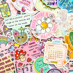 Pode incluir: Uma coleção de autocolantes coloridos com vários desenhos e texto. Os autocolantes incluem uma margarida sorridente, uma bebida de coco, um cogumelo e um calendário. Os autocolantes têm um esquema de cores rosa e pastel.