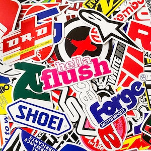 Pode incluir: Uma cole&ccedil;&atilde;o de autocolantes coloridos com v&aacute;rios logotipos e texto. Os autocolantes apresentam uma variedade de designs, incluindo as palavras "hella flush" em rosa, "SHOEI" em azul e "Forge Motorsport" em azul e vermelho.