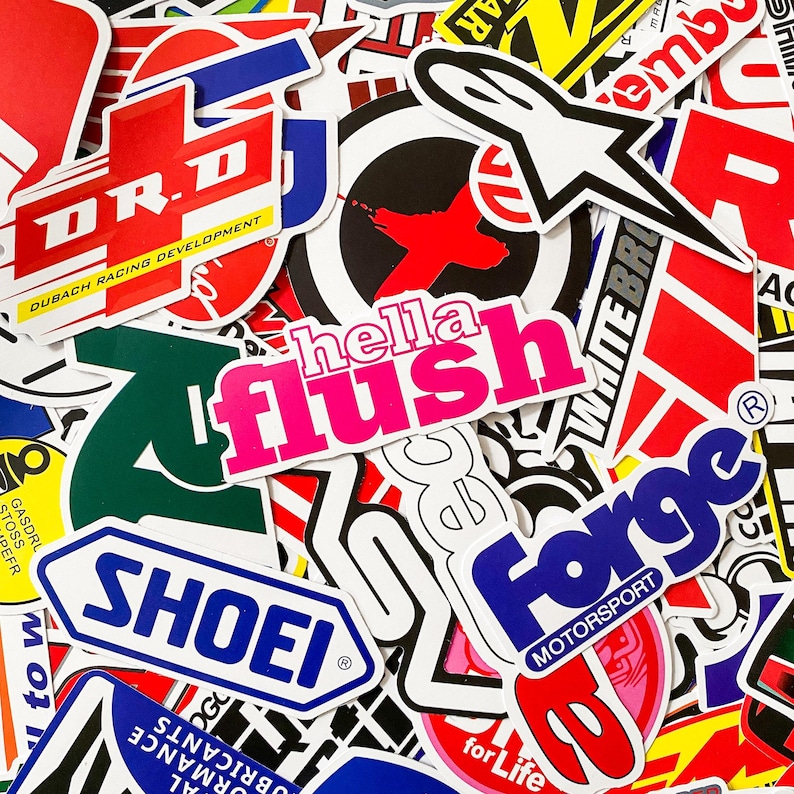 Pode incluir: Uma cole&ccedil;&atilde;o de autocolantes coloridos com v&aacute;rios logotipos e texto. Os autocolantes apresentam uma variedade de designs, incluindo as palavras "hella flush" em rosa, "SHOEI" em azul e "Forge Motorsport" em azul e vermelho.