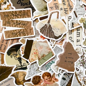 May include: A collection of decorative stickers with a vintage aesthetic. The stickers feature various designs, including a basket, floral patterns, text like "Be Fearless," and cherubic figures. The color palette includes browns, creams, and hints of green.