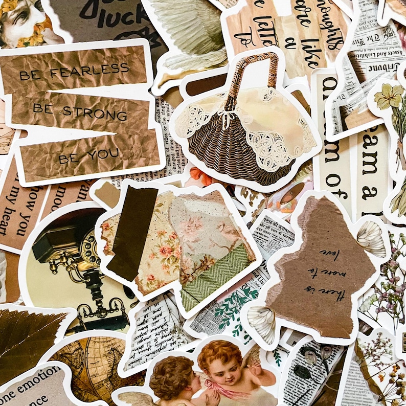 May include: A collection of decorative stickers with a vintage aesthetic. The stickers feature various designs, including a basket, floral patterns, text like "Be Fearless," and cherubic figures. The color palette includes browns, creams, and hints of green.