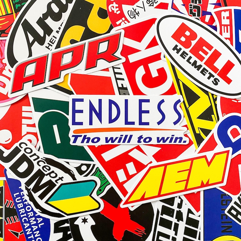 Pode incluir: Uma cole&ccedil;&atilde;o de autocolantes coloridos com v&aacute;rios log&oacute;tipos e texto. Os autocolantes proeminentes incluem "APR" em vermelho e branco, "ENDLESS Tho will to win," e "BELL HELMETS." Os autocolantes s&atilde;o de v&aacute;rias formas e tamanhos, com um tema de corrida ou autom&oacute;vel.