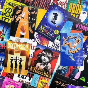 Könnte beinhalten: Eine Sammlung farbenfroher Musical-Programmhefte, darunter "Hamilton", "Matilda", "Dreamgirls", "Les Misérables" und "Anything Goes". Die Programmhefte zeigen verschiedene Designs und Illustrationen, die die Vielfalt der Produktionen widerspiegeln.