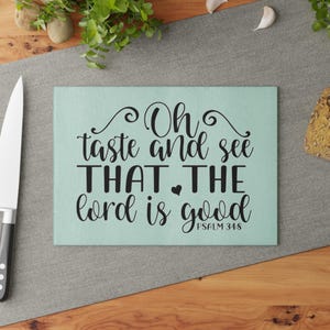 May include: A light blue chopping board with the text "Oh taste and see THAT THE lord is good PSALM 34:8" in black lettering.