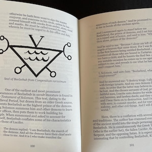 May include: An open book with black text on white pages. The left page features a black line drawing of the Seal of Beelzebub, a triangle with a V on top and wavy lines inside. The text discusses the Testament of Solomon and Beelzebub.