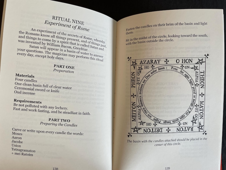 May include: An open book displaying pages 138 and 139, featuring black text on white paper. The left page details Ritual Nine, Experiment of Rome, listing materials and preparation steps. The right page shows a square diagram with a central circle.