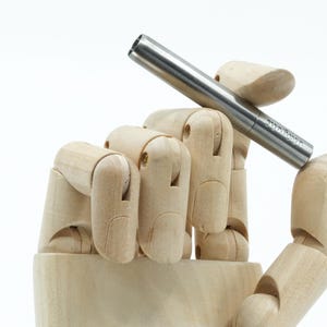 Pode incluir: Uma caneta de metal prateada com a palavra "Remarkable" gravada no lado.