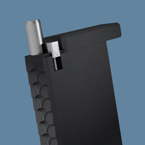 May include: A black, rectangular, textured case with a silver metal top. The case has a small, silver metal lever on the side.
