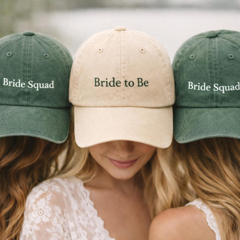 May include: Three baseball caps, one beige and two green, with the text "Bride to Be" and "Bride Squad" embroidered on the front. The caps are worn by people with blonde and brown hair.