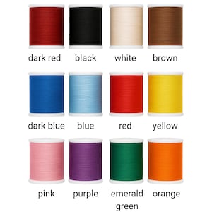 May include: A selection of thread spools in a range of colours: dark red, black, white, brown, dark blue, blue, red, yellow, pink, purple, emerald green, and orange. Each spool is labelled with its colour name.
