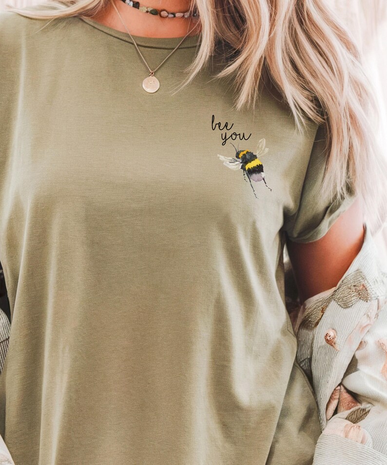 May include: A green t-shirt with the text "be you" and a bee graphic on the front.