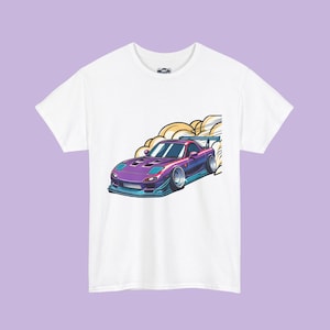 May include: White t-shirt featuring a stylized illustration of a purple and blue sports car with a rear spoiler, emitting a cloud of smoke. The car design has a low profile and racing aesthetic. The shirt is made of a soft, comfortable material.