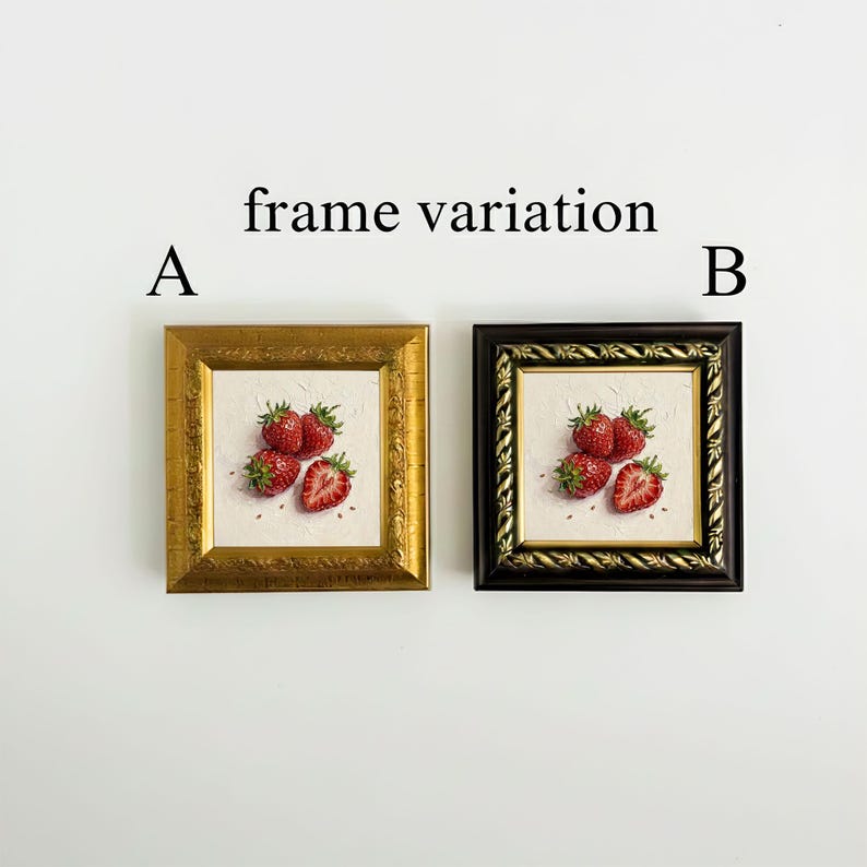 May include: Two framed strawberry art prints. One frame is gold, the other is black. Each print features a still life of ripe strawberries on a white background. The text "frame variation" is above the frames, with "A" and "B" to the left and right.