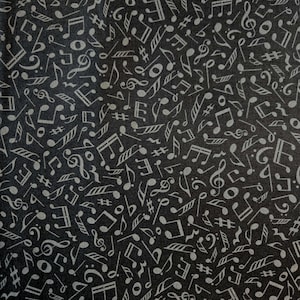 May include: Black fabric with a repeating pattern of musical notes, clef symbols, and sharps in a light gray color. The musical symbols are scattered across the dark background.