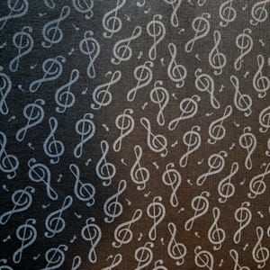 May include: Dark gray fabric with a repeating pattern of light gray treble clef symbols and musical notes. The design is evenly distributed across the fabric, creating a musical theme.