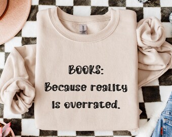 May include: A beige sweatshirt with the text "BOOKS: Because reality is overrated." printed in black.